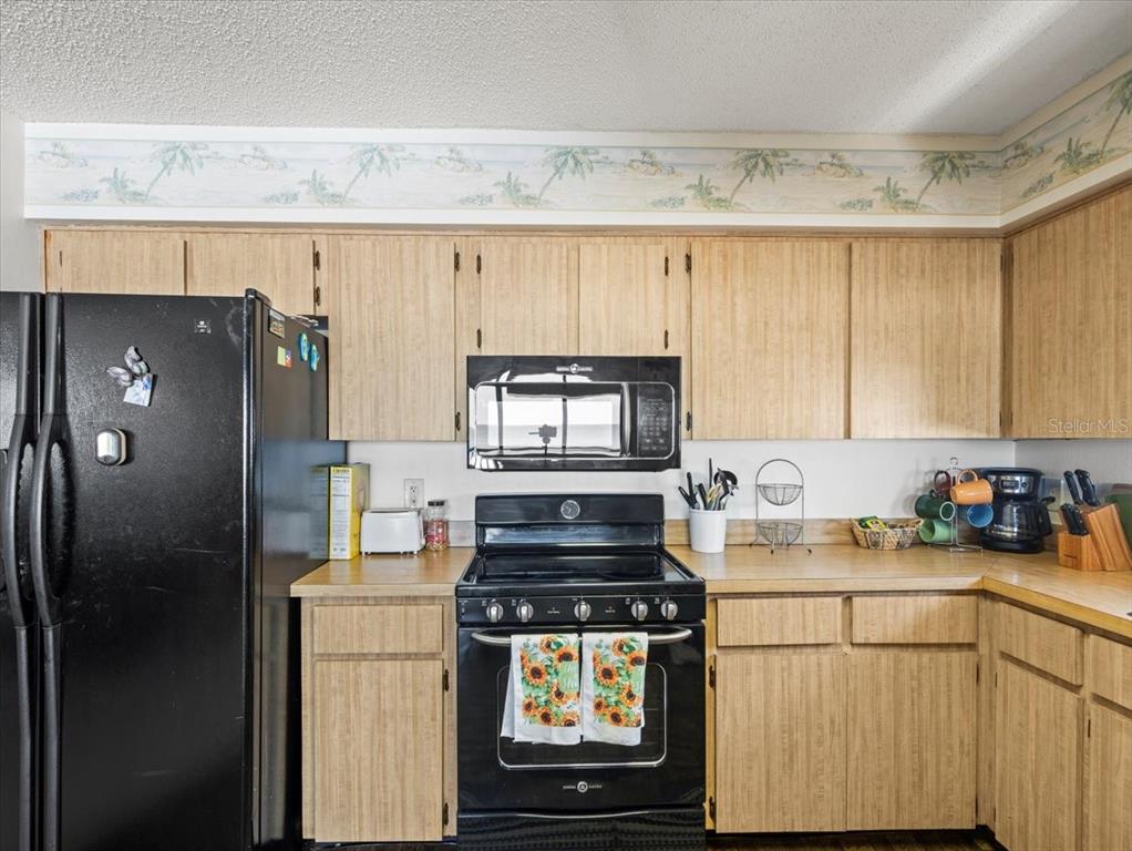 18218 Sunset Boulevard, Unit A St. Petersburg, FL 33708 - Photo 39 of 48 a kitchen with a refrigerator and a stove top oven