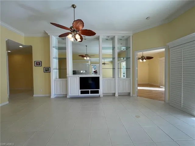a view of a livingroom with a chandelier fan and a kitchen