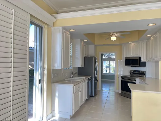a kitchen with stainless steel appliances granite countertop a sink and a refrigerator
