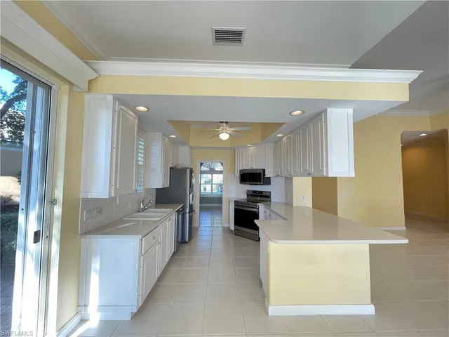 a large kitchen with a large counter top appliances and cabinets
