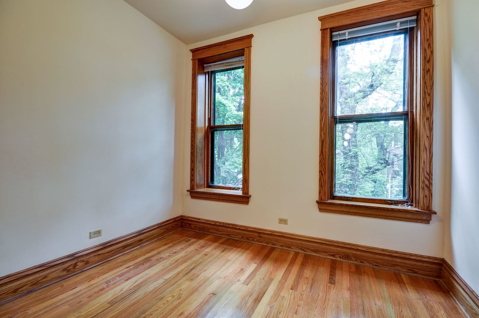 3722 North Fremont Street, Unit 2 Chicago, IL 60613 - Photo 12 of 16 an empty room with wooden floor and windows