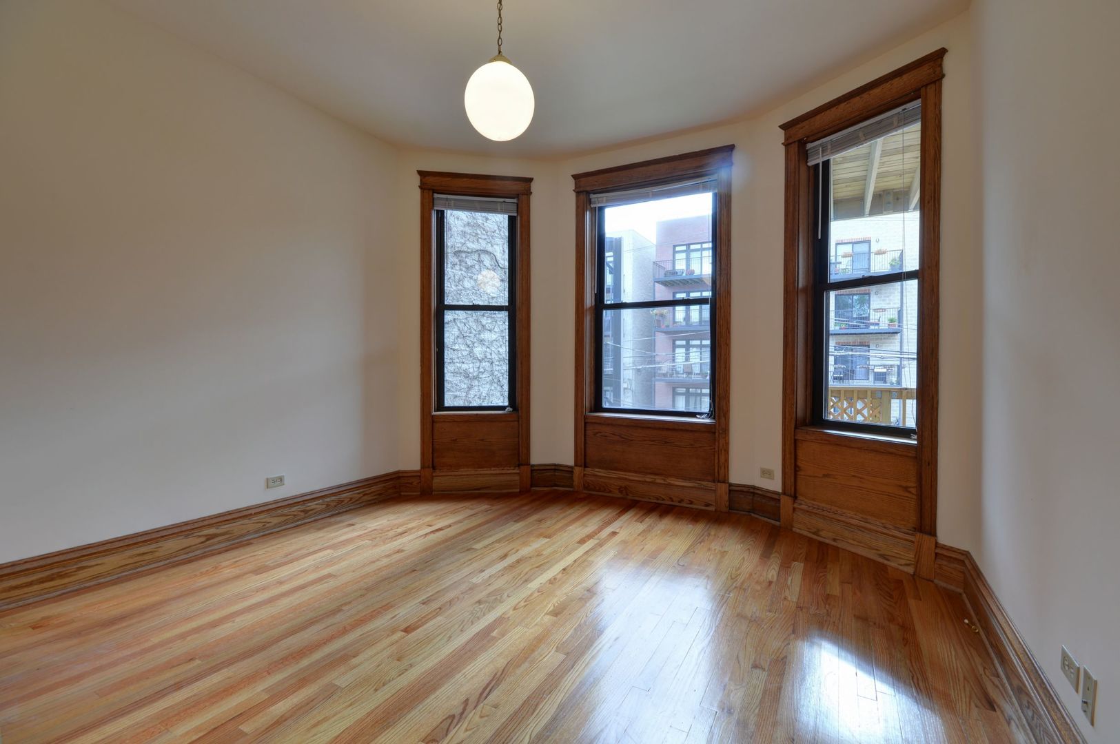 3722 North Fremont Street, Unit 2 Chicago, IL 60613 - Photo 4 of 16 an empty room with wooden floor and windows