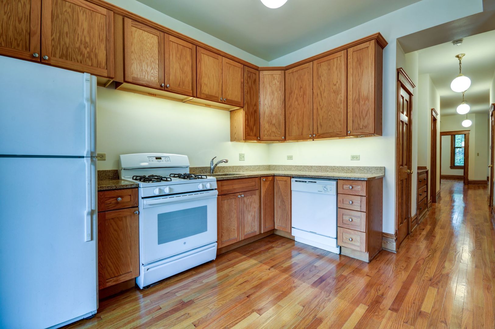 3722 North Fremont Street, Unit 2 Chicago, IL 60613 - Photo 6 of 16 a kitchen with stainless steel appliances granite countertop a refrigerator a stove and a wooden floors