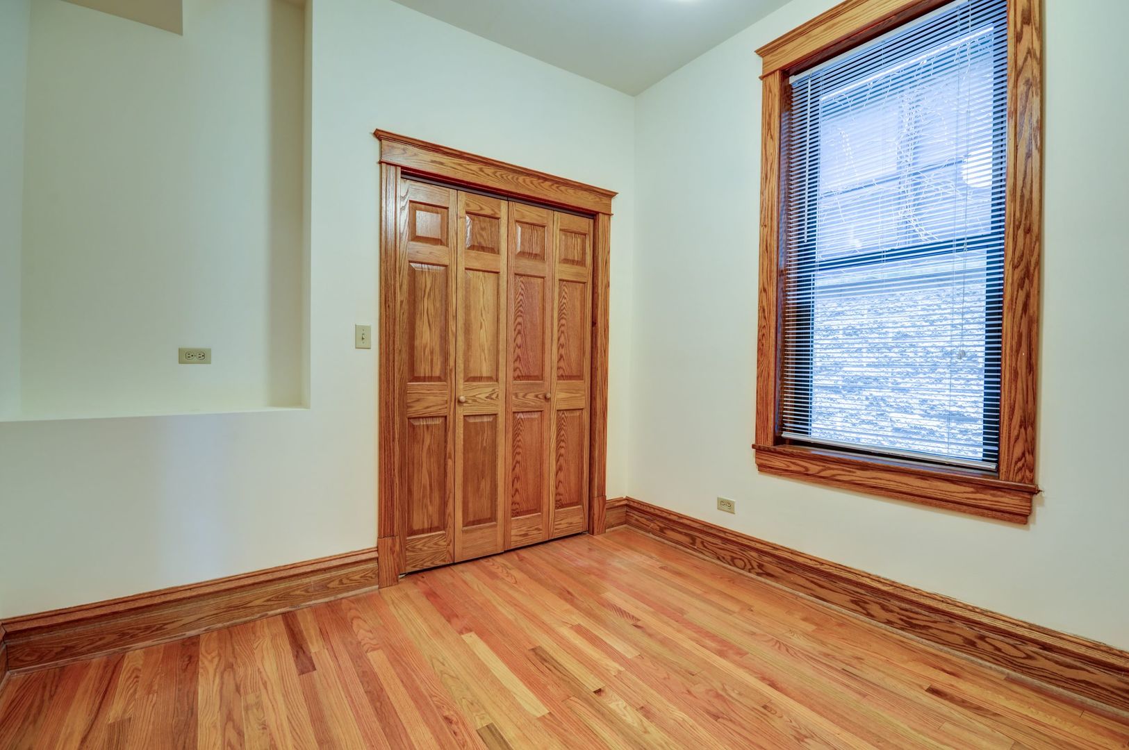 3722 North Fremont Street, Unit 2 Chicago, IL 60613 - Photo 8 of 16 a view of an empty room with wooden floor and a window