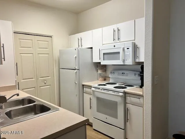 a kitchen with white cabinets and white appliances