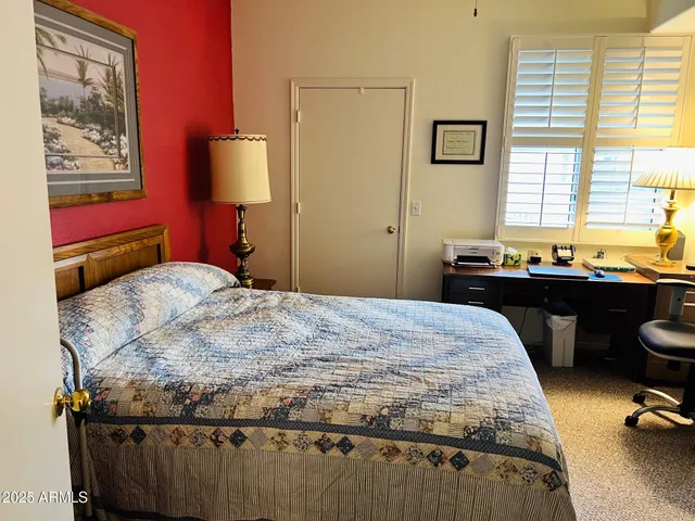 a bedroom with a bed and a lamp on dresser