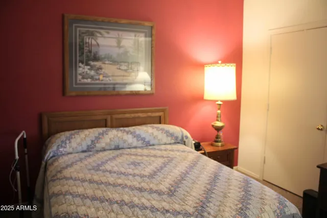 a bedroom with a bed and a painting on the wall