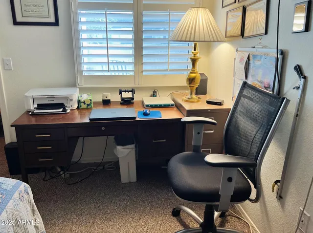 a view of a workspace with furniture and a window