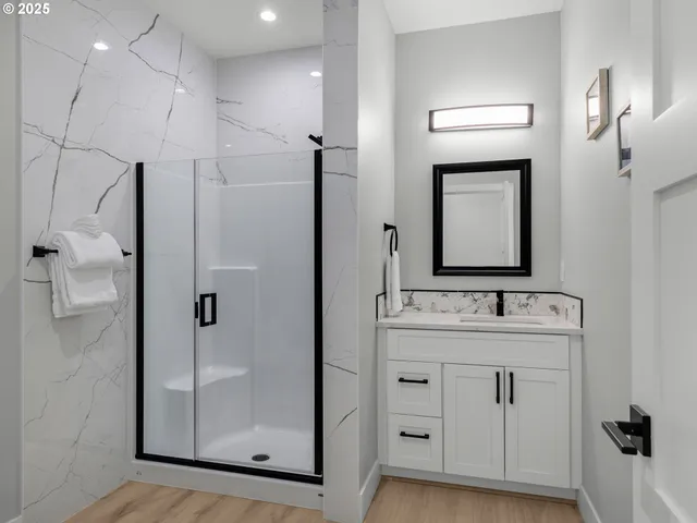 a bathroom with a double vanity sink mirror and shower