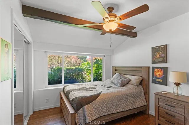 a bedroom with a bed a dresser and a chandelier