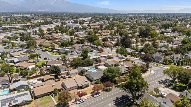 an aerial view of residential houses with outdoor space and trees