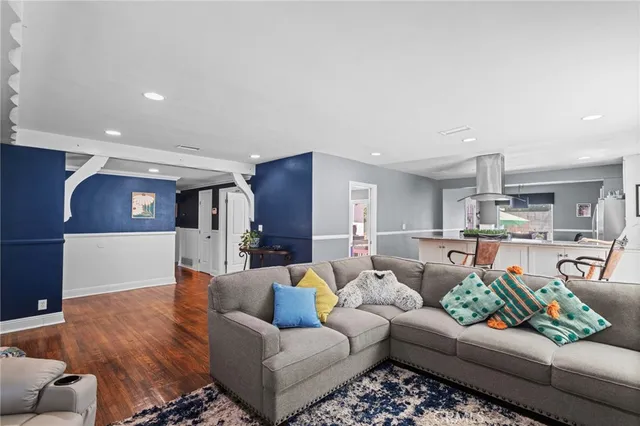 a living room with furniture and view of kitchen