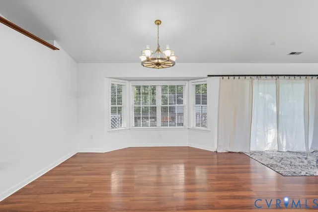 a view of a livingroom with furniture wooden floor and chandelier