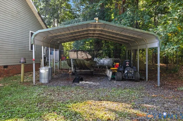 a view of backyard with large trees and wooden fence