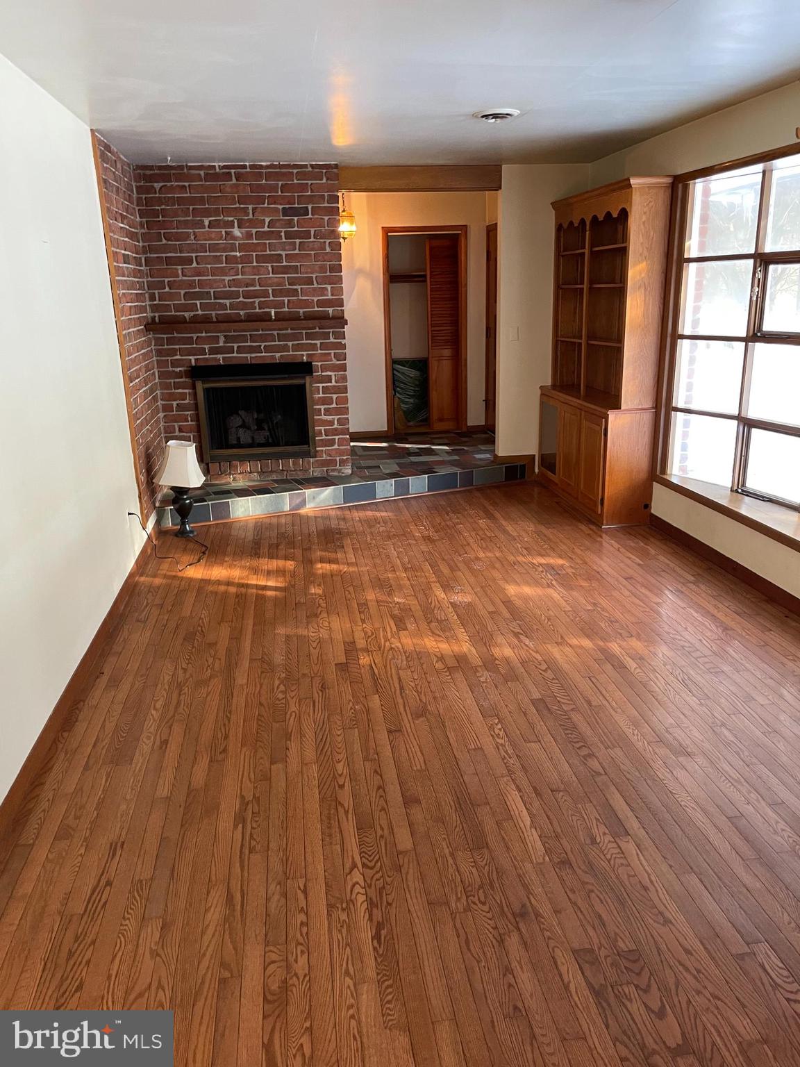 60 Ridge Road Gettysburg, PA 17325 - Photo 22 of 41 an empty room with wooden floor fireplace and windows