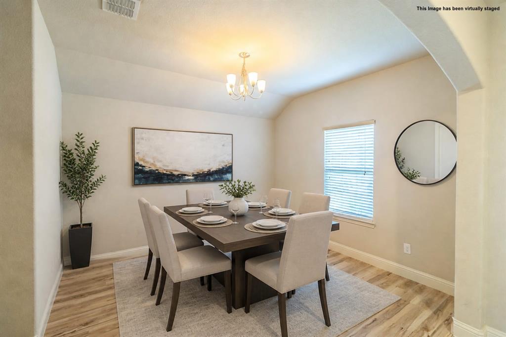 Virtual staged=>Dining space with wood-finish flooring, an arched entryway, and a single window with horizontal blinds