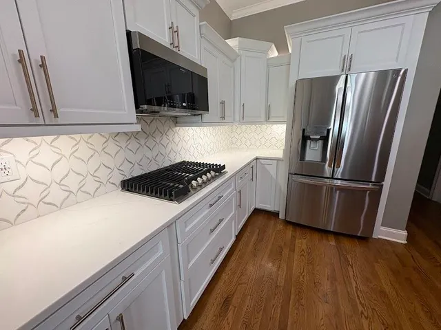 a kitchen with stainless steel appliances a refrigerator a sink a stove a microwave and wooden floors