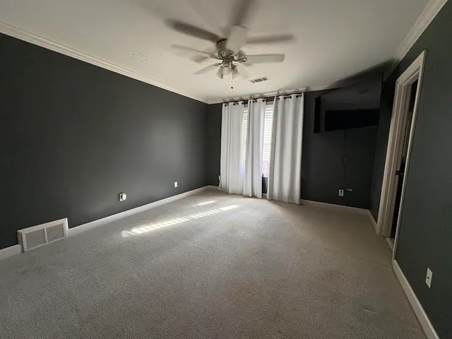 a view of a livingroom with a ceiling fan and window