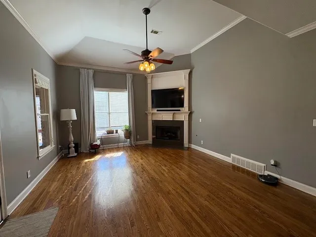 a view of a livingroom with wooden floor and a ceiling fan