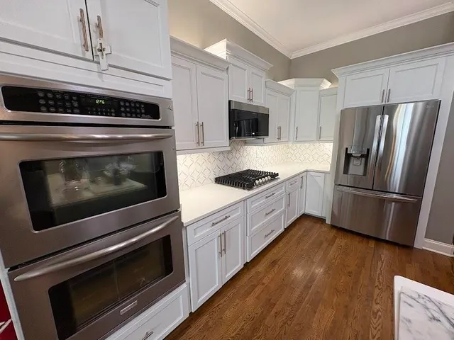 a kitchen with granite countertop a stainless steel appliances and wooden floor