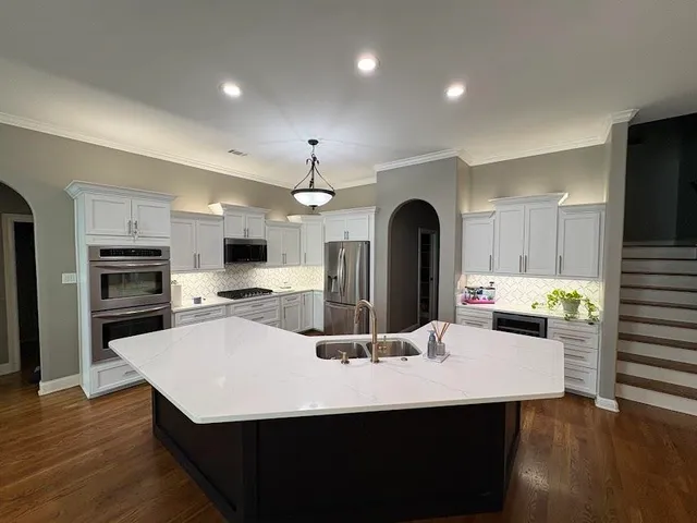 a kitchen with a sink a counter space and stainless steel appliances