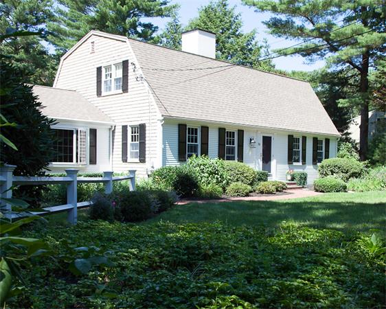 a view of white house with a yard and potted plants
