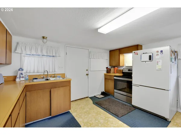 a kitchen with a refrigerator and a stove top oven
