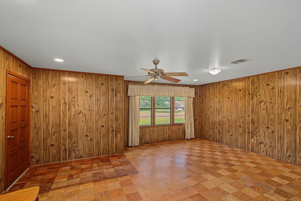 2604 Rosedale Place Bossier City, LA 71111 - Photo 6 of 26 Wood-paneled walls with contrasting white ceiling, recessed lighting, and a ceiling fan with integrated light fixture