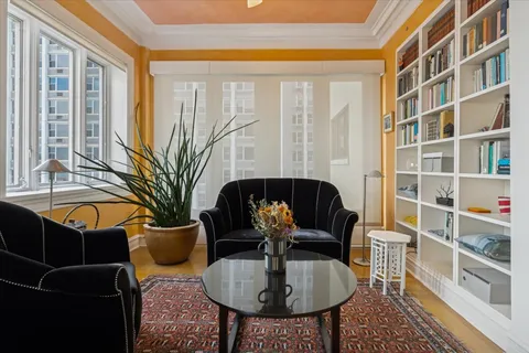 a living room with furniture potted plant and a large window