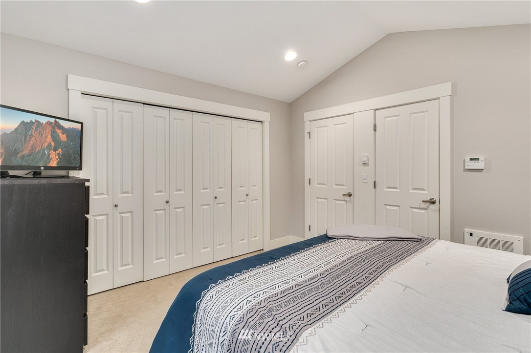 10303 Holman Road North, Unit C Seattle, WA 98177 - Photo 13 of 23 a bedroom with a bed and a flat tv screen