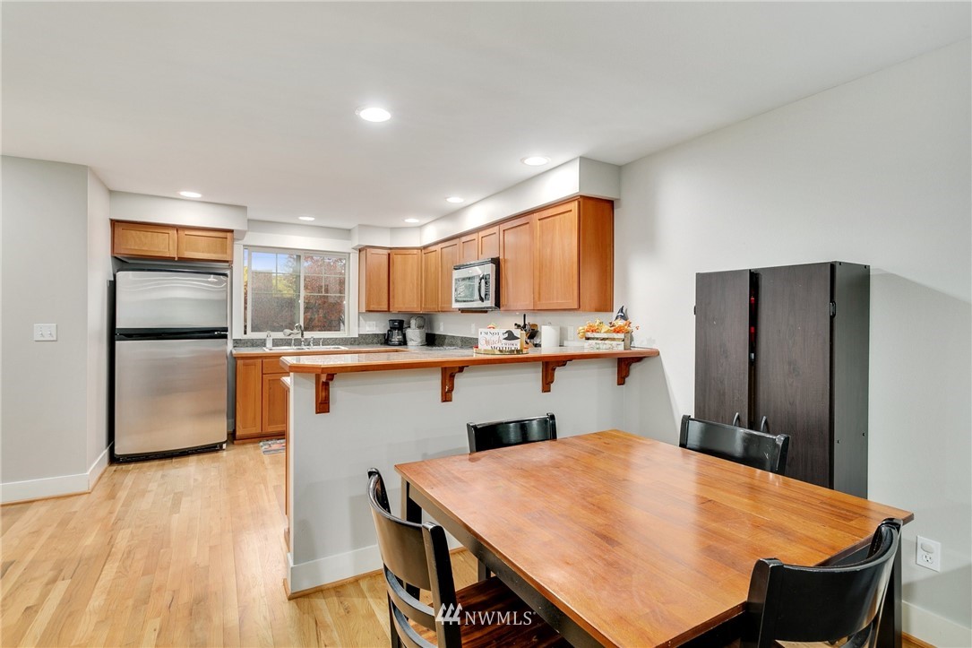 10303 Holman Road North, Unit C Seattle, WA 98177 - Photo 6 of 23 a kitchen with kitchen island a refrigerator stove microwave and cabinets