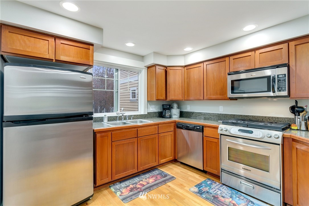 10303 Holman Road North, Unit C Seattle, WA 98177 - Photo 9 of 23 a kitchen with stainless steel appliances granite countertop a stove a sink and a microwave