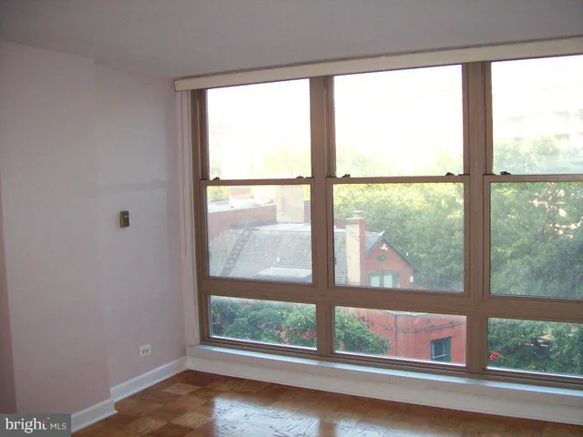 an empty room with wooden floor and a window