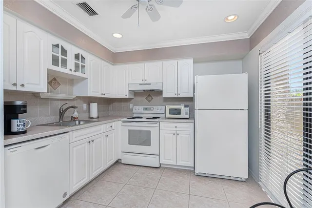 a kitchen with white cabinets and white appliances