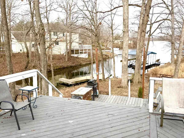 a view of a roof deck with table and chairs with wooden floor and fence