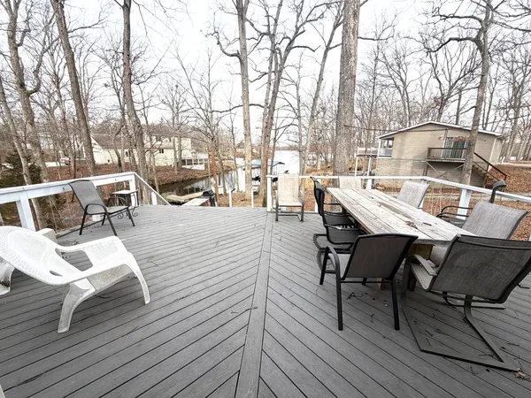a view of a patio with table and chairs with wooden floor and fence