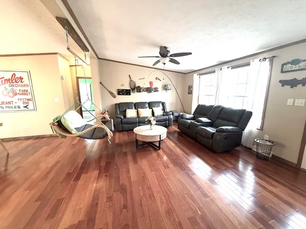 a living room with furniture and a wooden floor