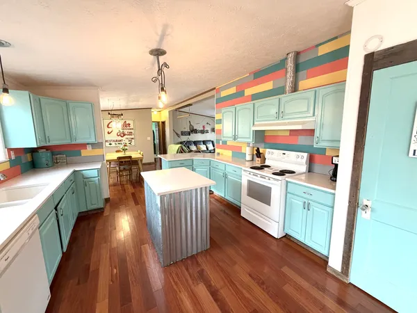 a kitchen with stainless steel appliances granite countertop a stove a sink and a wooden floors