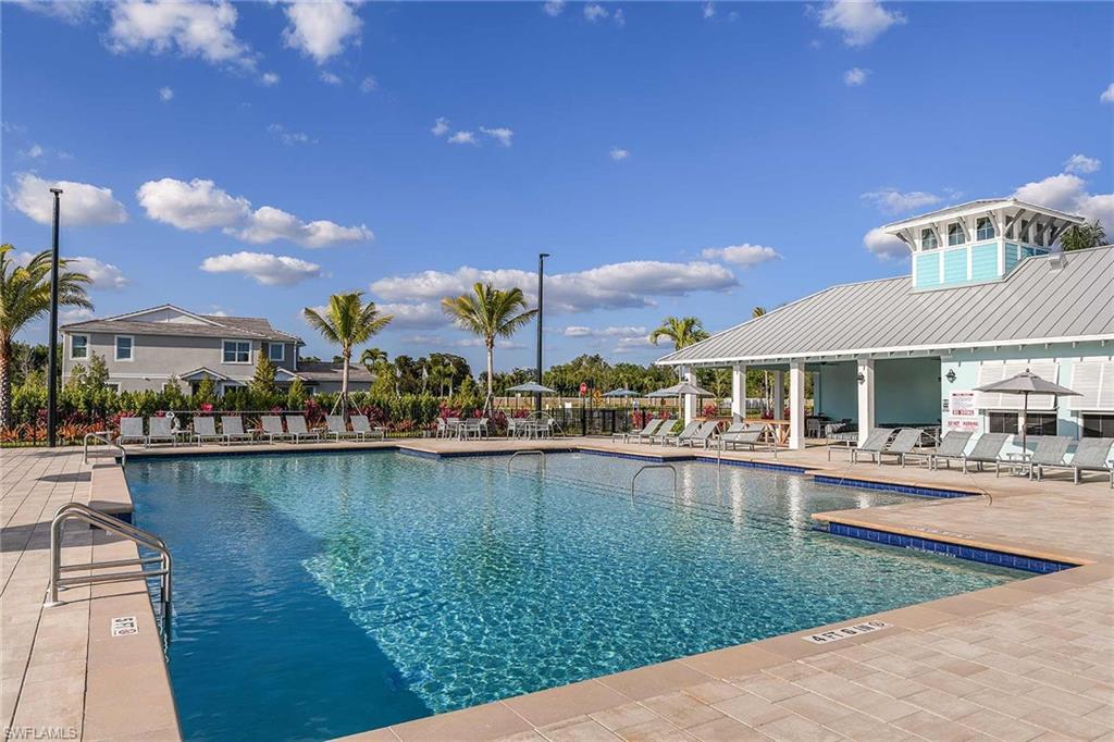 4551 Arboretum Circle, Unit 203 Naples, FL 34112 - Photo 19 of 22 a view of a lake with a house and a yard