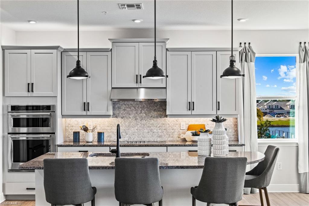 4551 Arboretum Circle, Unit 203 Naples, FL 34112 - Photo 4 of 22 a kitchen with stainless steel appliances granite countertop a sink a stove and refrigerator