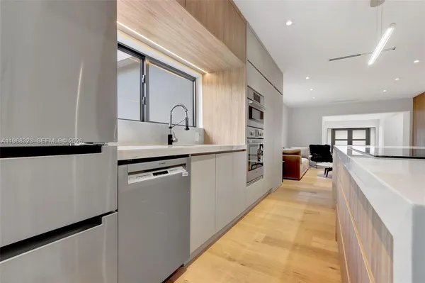 a kitchen with stainless steel appliances granite countertop a sink and dishwasher with white cabinets