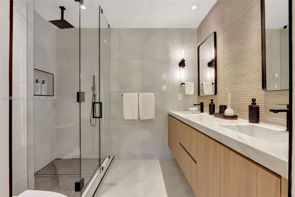 a bathroom with a double vanity sink a mirror and a shower