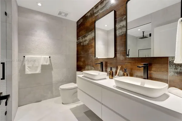 a bathroom with a double vanity sink toilet and mirror