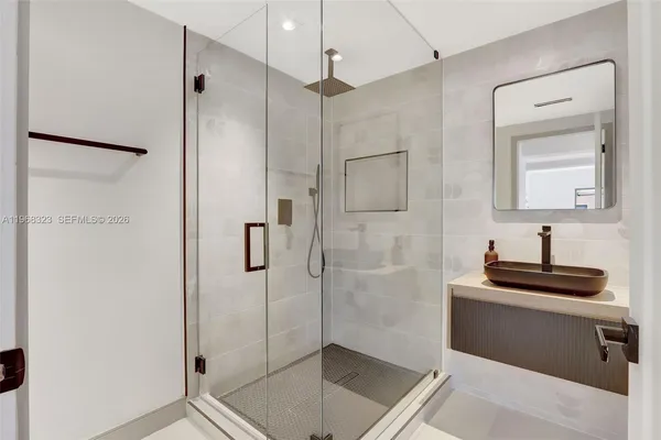 a bathroom with a shower sink and mirror