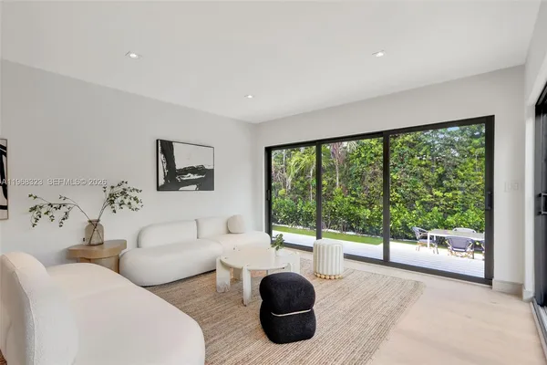 a living room with furniture a large window and a flat screen tv