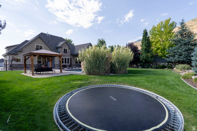 687 South 2080th Street East Springville, UT 84663 - Photo 95 of 149 Expansive backyard featuring a manicured lawn, a built-in swimming pool, and a stone retaining wall
