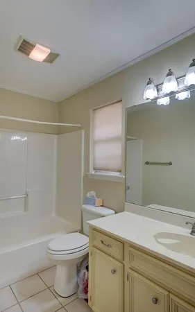 a bathroom with a granite countertop sink a toilet and shower