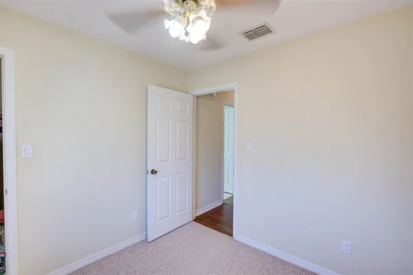 an empty room with a chandelier fan