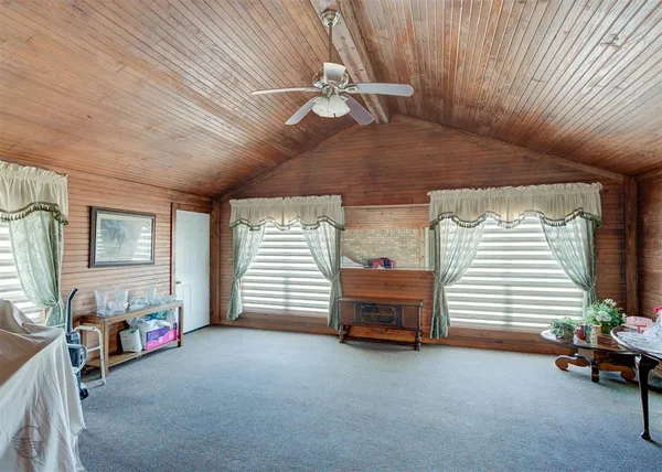 a view of a livingroom with a chair and a ceiling fan