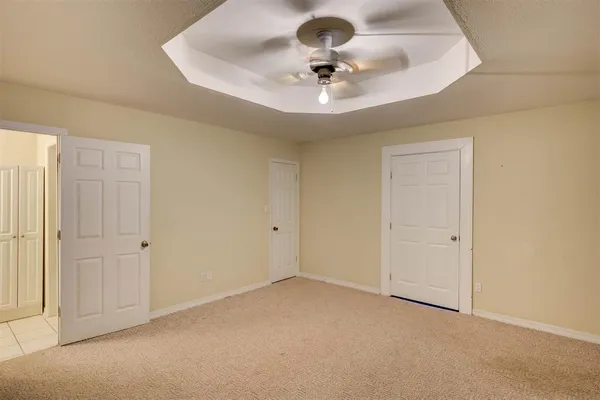 a view of an empty room with a chandelier fan